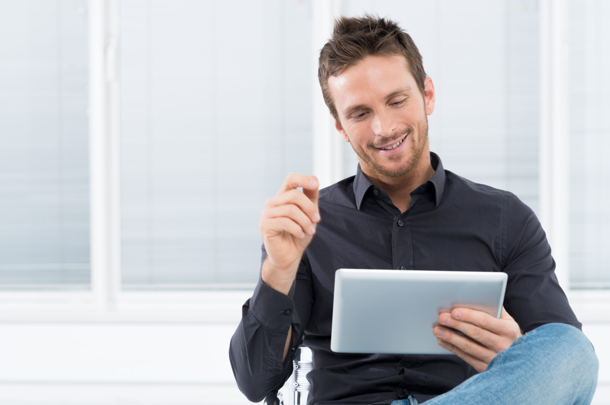 Portrait Of A Handsome Young Happy Man Using Digital Tablet